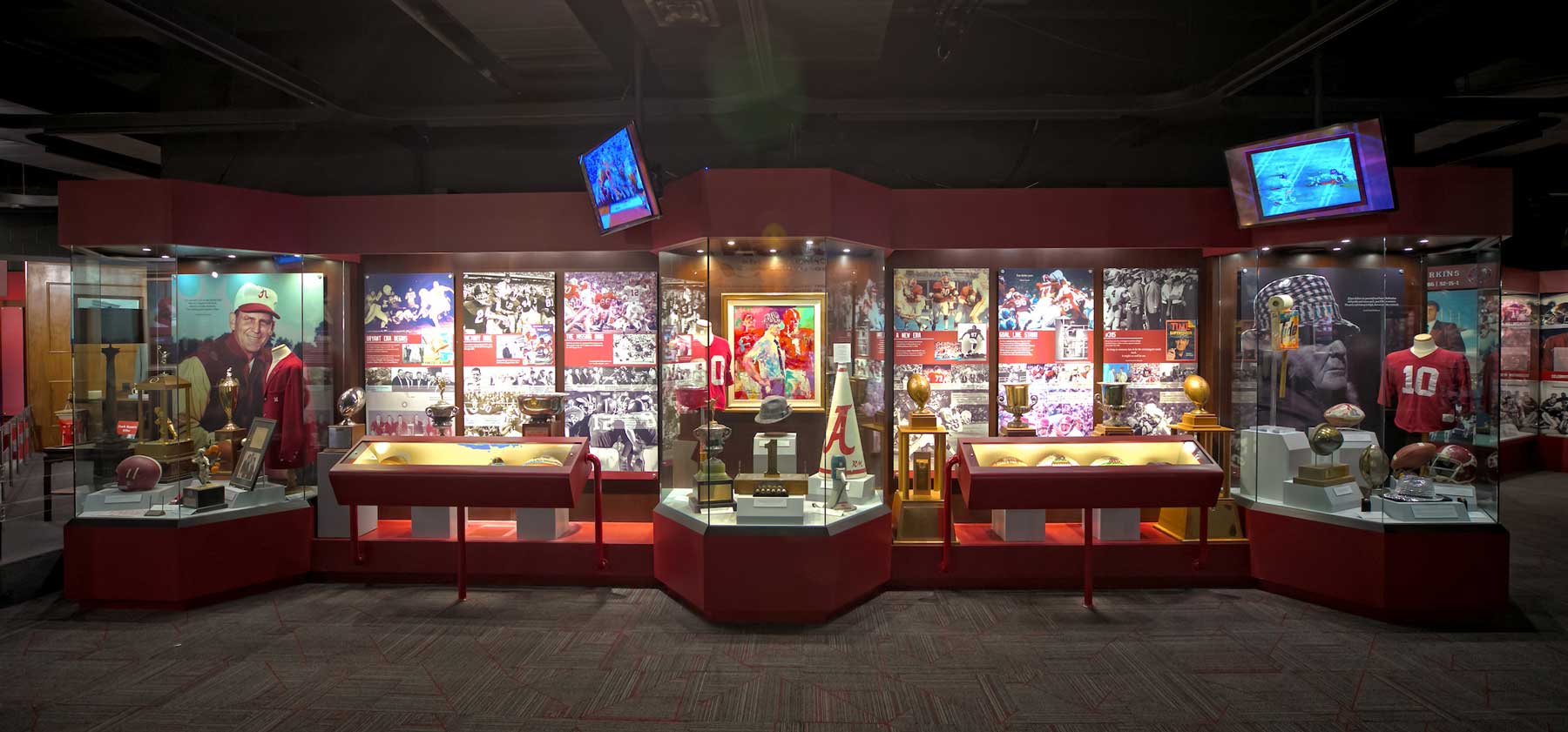 wall-length display of Crimson Tide trophies