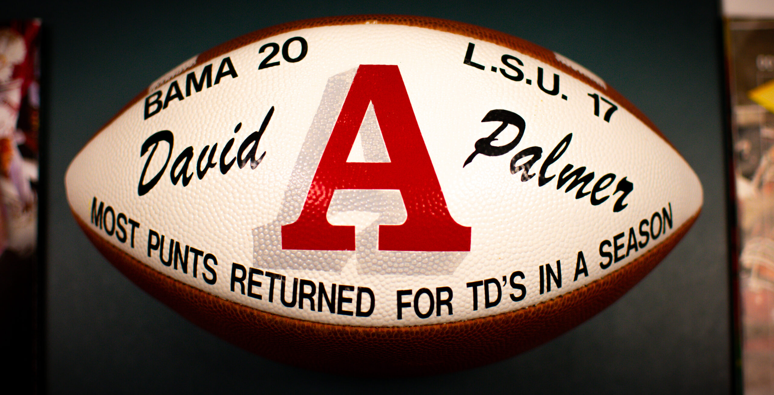 Football with the scores "Bama 20, L.S.U. 17" and "David Palmer, Most Punts Returned for TDs in a Season" printed on it.