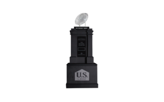 A black trophy with a crystal football on top, labeled "The Coaches' Trophy." The base features the AFCA logo and "U.S. LBM." It is awarded to the National Champion in college football.